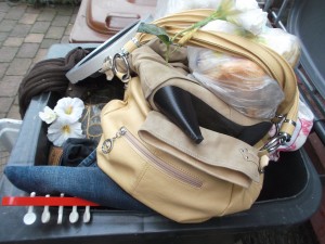 Sowas können nur Frauen: Eine Damenhandtasche voll mit ekligem und geilen Dreck. Ebendrauf weiße Plastikblumen wie bei einem Begräbnis.