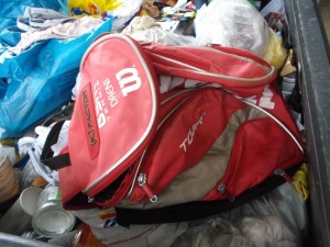 Ein ausrangierter Rucksack für Tennissachen; innen schmutzig vor rotem Sandplatzdreck.