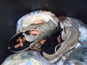 Ein (von Laura?) angebissener Schokoriegel liegt auch in der Mülltonne. Die armen Würstchen in und um die Sneakers fangen an zu schimmeln.