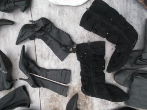 Kaputtgepresste, verschrammte und zerbrochene Stiefel und geplättete Wildlederstiefel, gespickt mit Presssplitter.