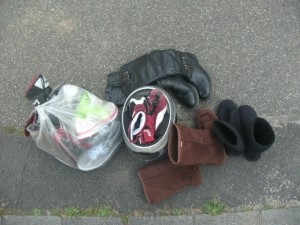 In einer Mülltüte einige Sneakers und eine lederne Bauchbinde, wie sie Biker tragen. daran geknotet ein Paar Puma-Stiefel und andere Pumas in ihren ausrangierten Helm praktischerweise gestopft. Nette Stiefel und verlatschte Uggs dazugestellt.