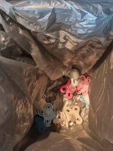 Schnuller in einer leeren Mülltonne