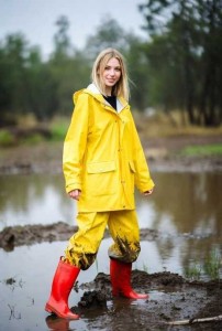 Vrouw geel regenpak rode laarzen in de modder.jpg